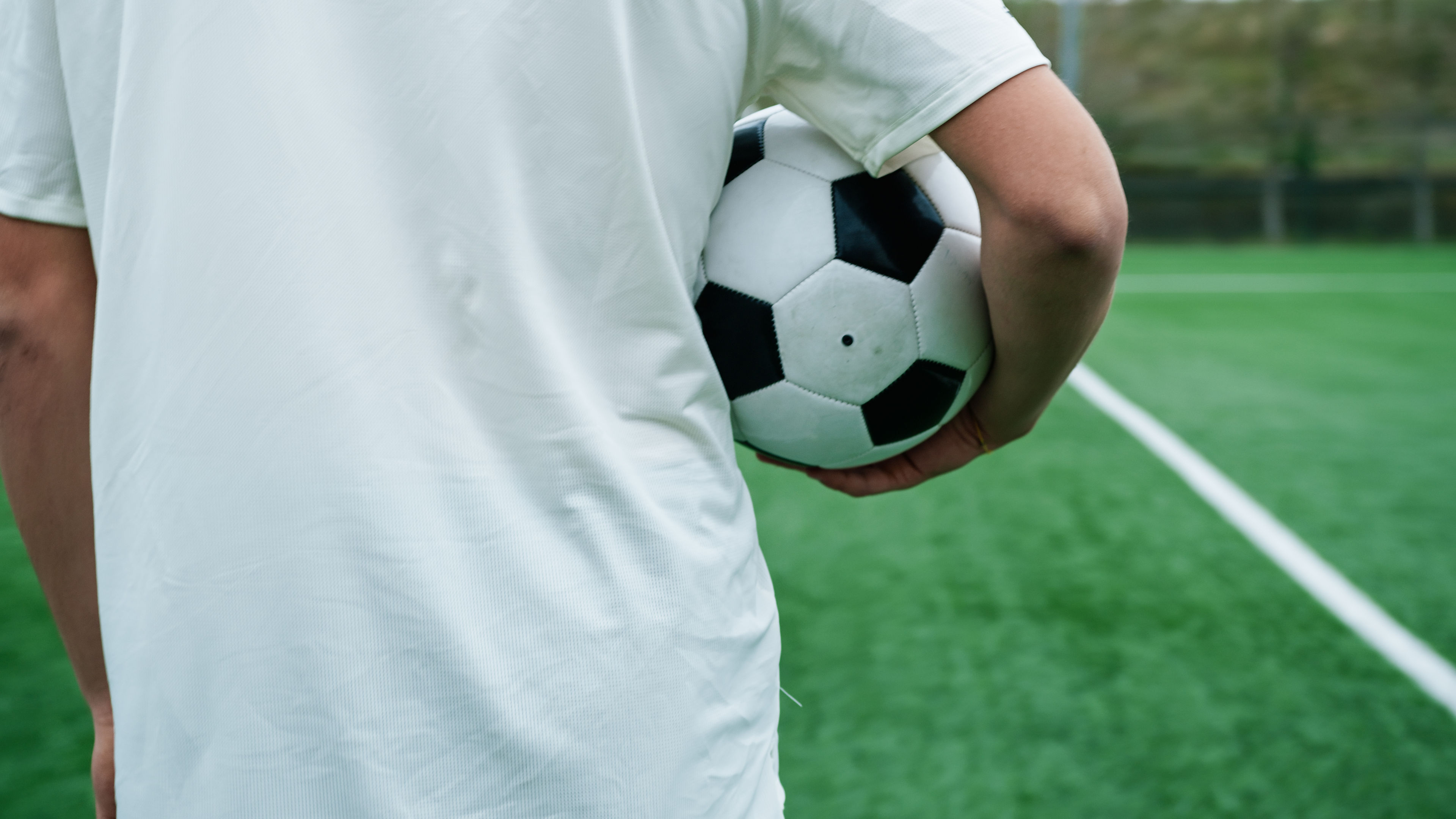 A football holding in a hand.