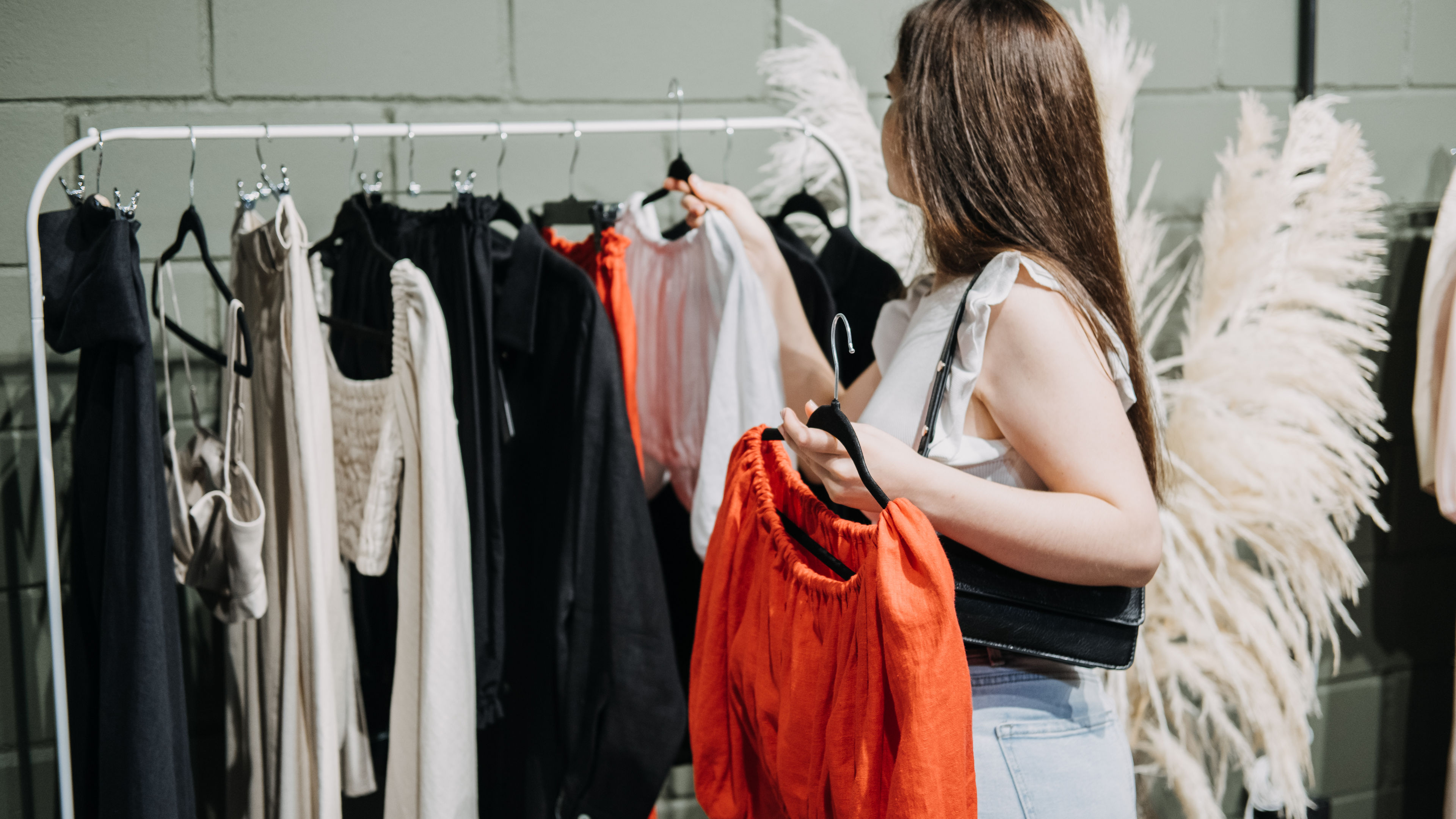 A woman holding a red top.