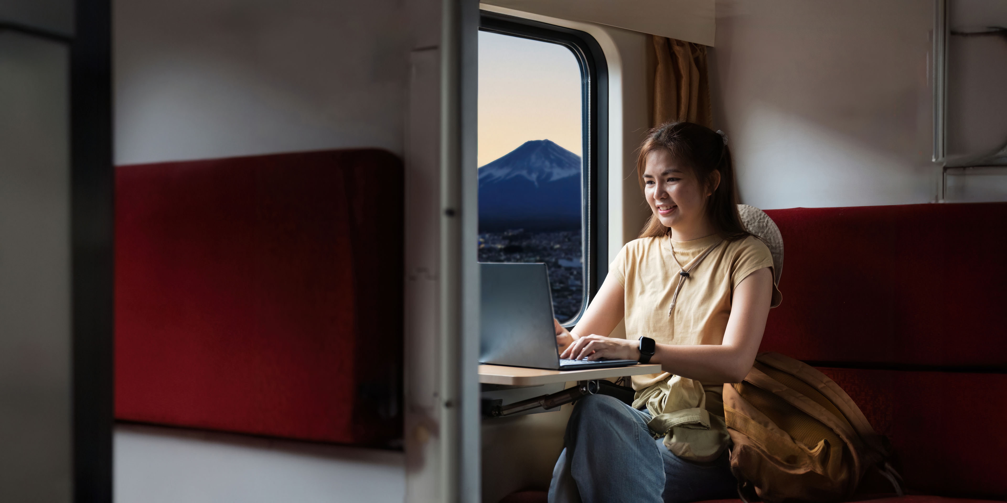 A young traveler is sitting on a train 