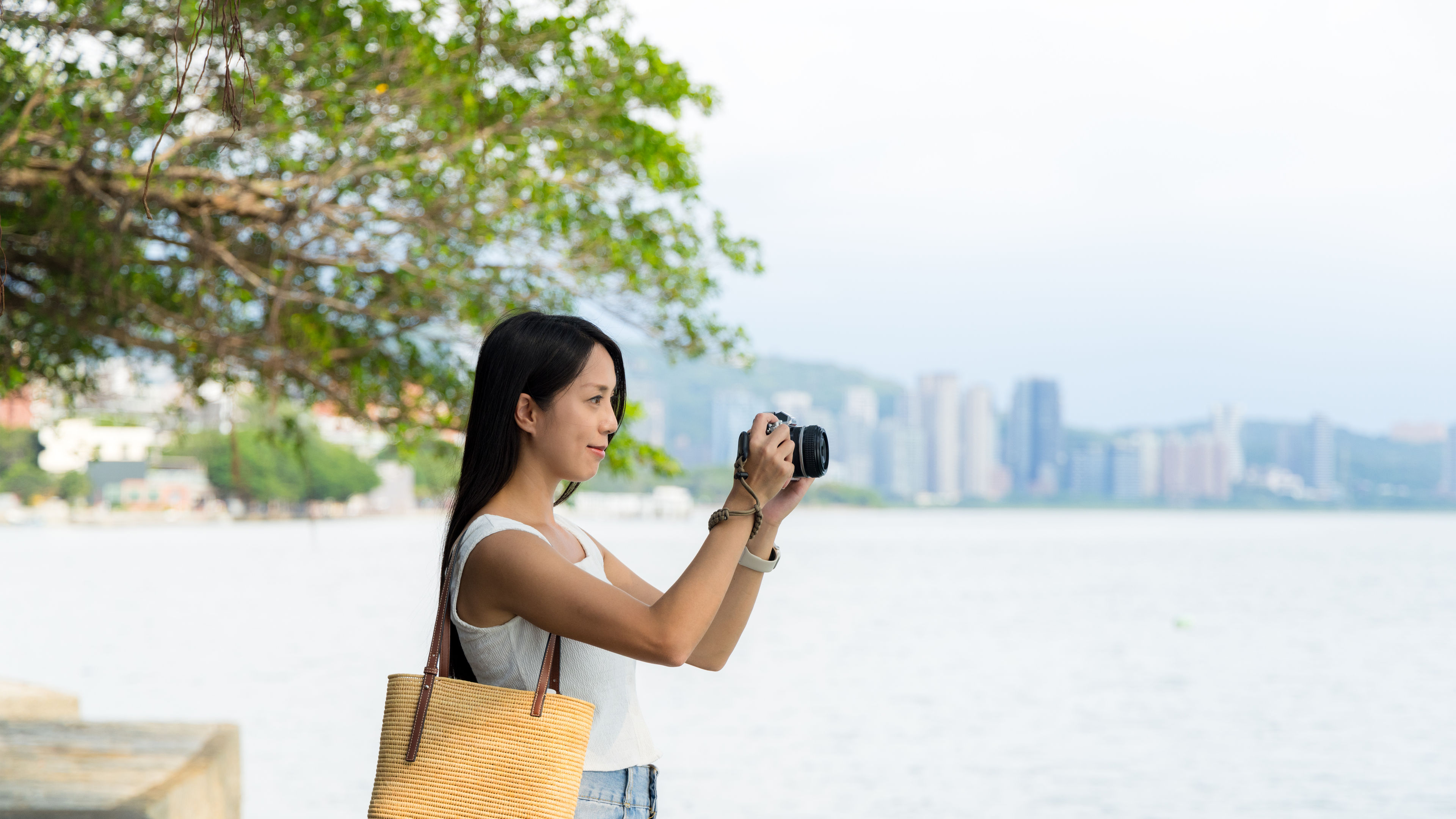 A young woman stands near the water. 