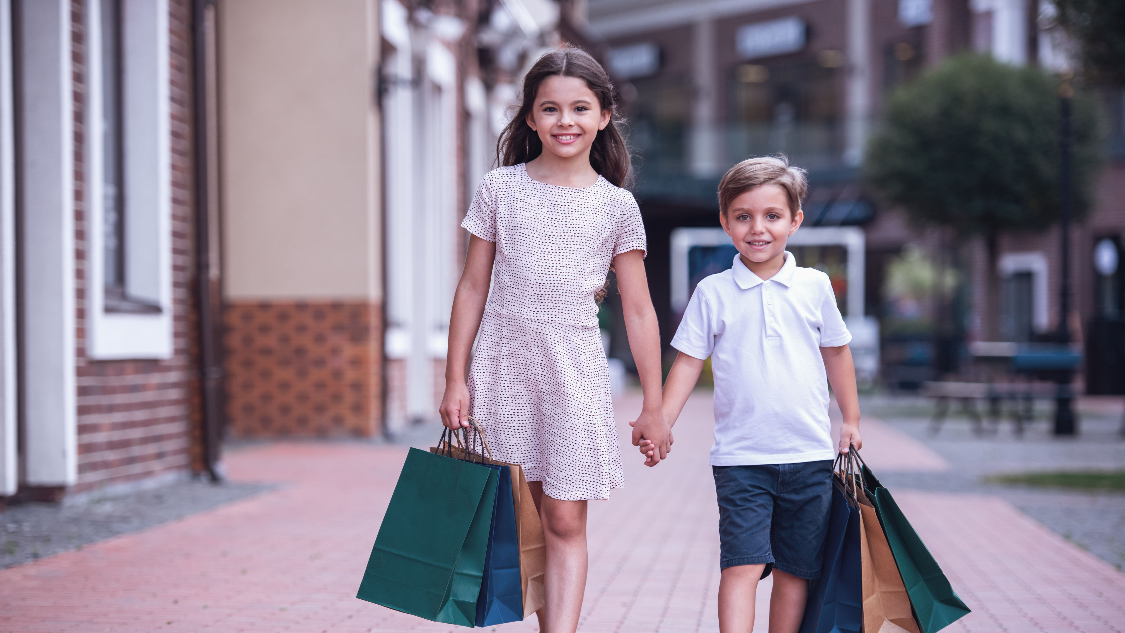 Cute little kids are carrying shopping bags