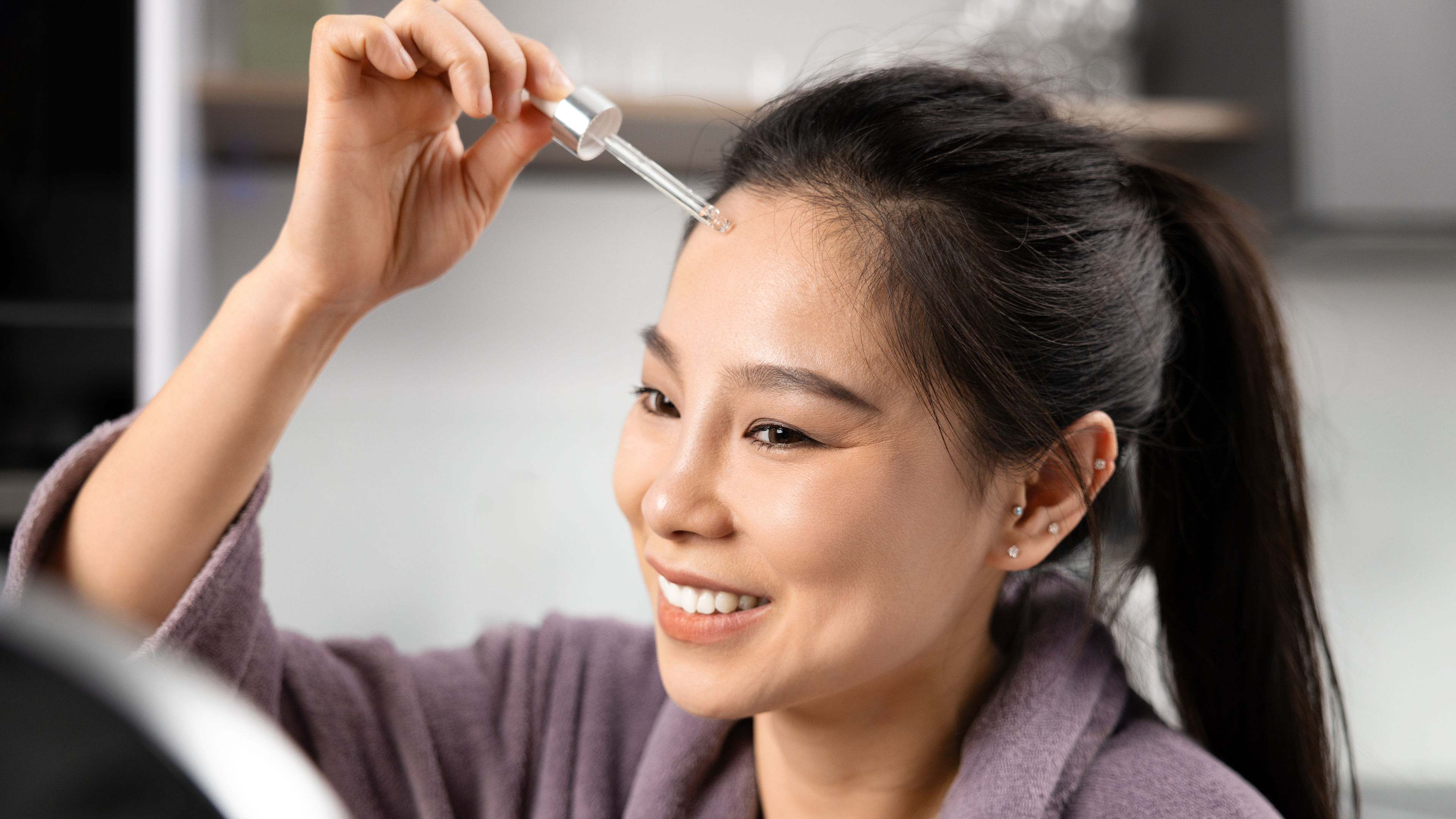Girl applying serum on face
