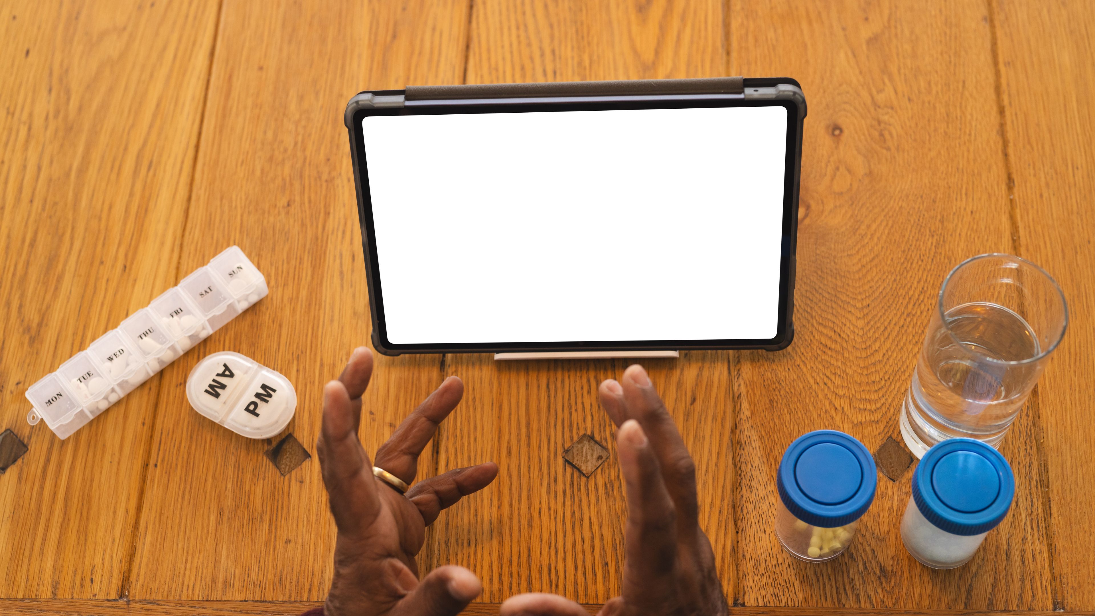 Senior man having video call with doctor on tablet with copy space